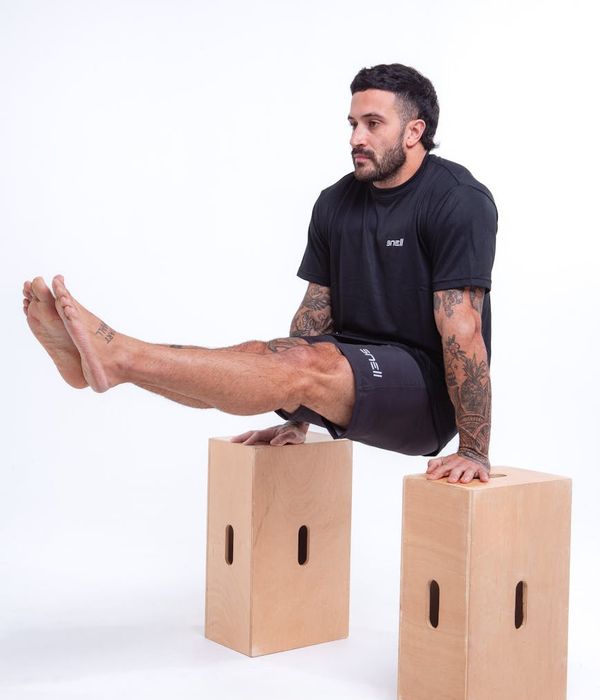 Man performing a controlled strength exercise in a modern gym.
